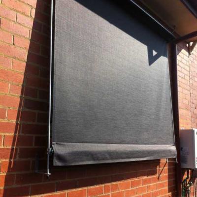 Outdoor Awning blinds installed on west side of house to prevent the harsh sun rays entering the room through the window, this is a straight drop awning made from black canvas.