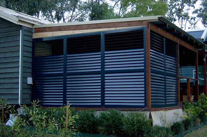 Outdoor Plantation Shutters for Alfresco, Patio, Cafes and Pergolas. White shutters with louver slats in open position.